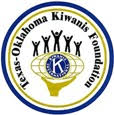 Logo of the Texas-Oklahoma Kiwanis Foundation. A hand holds an oval shaped globe with the Kiwanis International logo inside. Atop the globe are 5 human figures standing with arms raised upwards. The image is ringed by text Texas-Oklahoma Kiwanis Foundation, which is ringed by a gold band, which is then ringed by a blue band.
